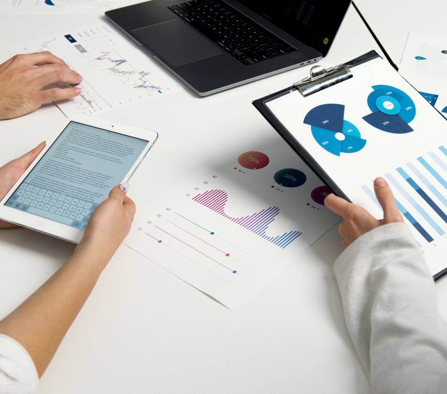 Team analyzing financial charts and digital reports during a business meeting.